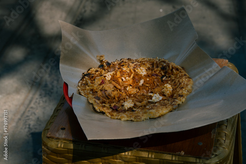 Kerak telor, a traditional street food from Jakarta, Indonesia. This food is an omelet with rice, served with fried grated coconut. Sold on a street stall photo