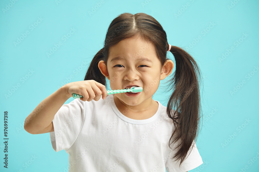 Happy asian ethnicity cute child girl use hand holds toothbrush, brushing teeth myself at morning every day standing over blue isolated background with copy space, health medical care Happy asian ethnicity cute child girl use hand holds toothbrush, brushing teeth myself at morning every day standing over blue isolated background with copy space, health medical care