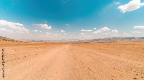 Desert Landscape with Dirt Road and Mountains Under Blue Sky