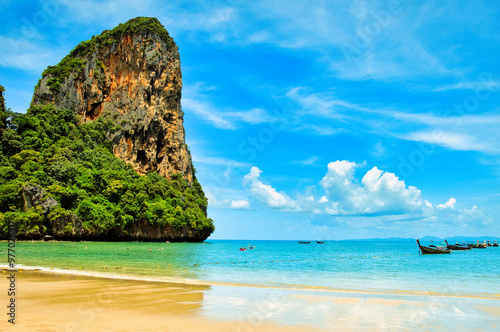 Railay Beach, Krabi Province, Thailand, 10 July 2023 : the beautiful seascape of sand beach, blue sky, sea and limestone mountains at seashore. Motor boats on turquoise waters. picture perfect hot day