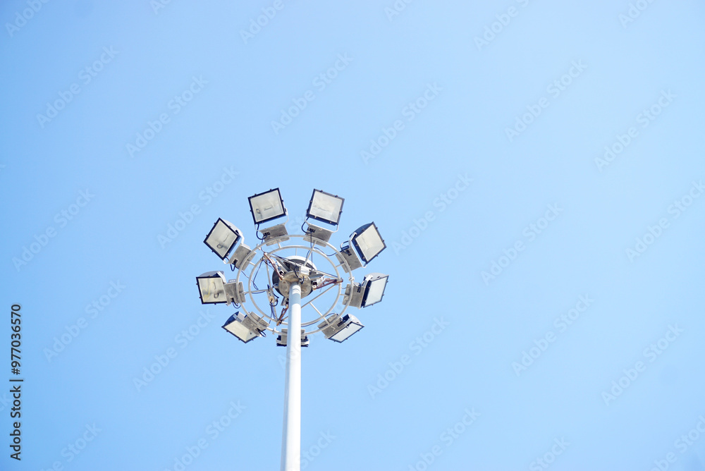 Low angle view of group of sport light pole with blue sky Low angle view of group of sport light pole with blue sky