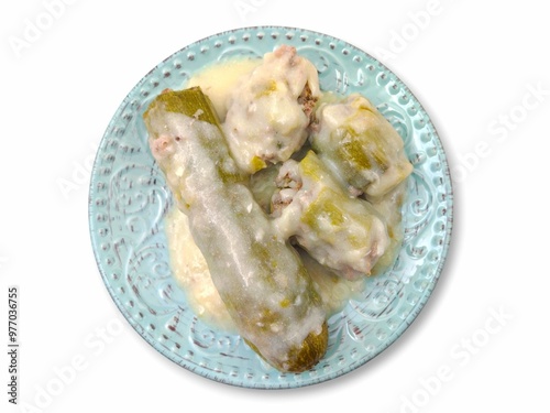 Top view of a delicious plate of stuffed zucchini with ground meat (gemista kolokythakia me kima), served with egg-lemon sauce (avgolemono), a traditional Greek recipe, isolated on white background. photo