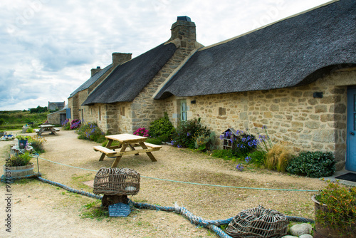 Traditional cotswold cottage with thatched roof and a table in Menahan, Kerlouan, Bretagne, France