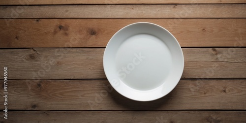 Bird s eye view of an empty white plate on a wooden table with copy space image. photo