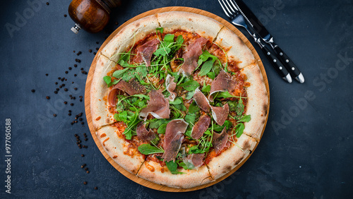 Italian food pizza with bacon, sun-dried tomatoes, cheese, arurgula and spices.