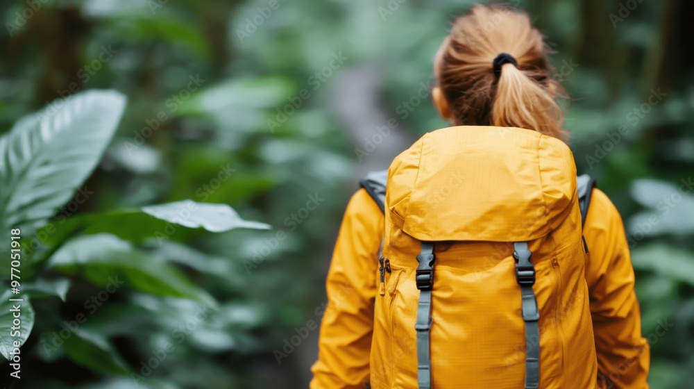 A person wearing a yellow jacket hikes through a rich, green jungle path, evoking themes of solitude, adventure, and the lush, untamed beauty of the wilderness. A person wearing a yellow jacket hikes through a rich, green jungle path, evoking themes of solitude, adventure, and the lush, untamed beauty of the wilderness.