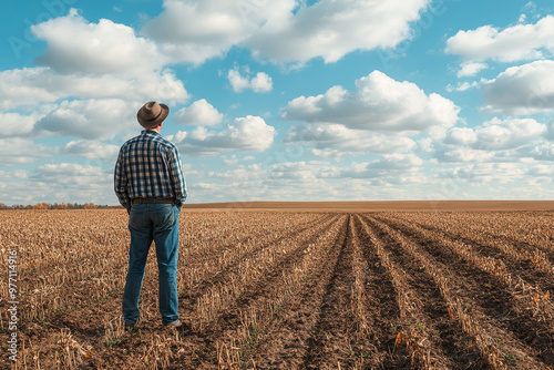 A farmer standing in a barren field, looking at wilted crops and an auction notice, symbolizing agricultural bankruptcy and the impact of economic downturns