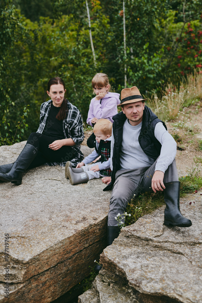 Happy family on a walk in the forest picking berries and herbs, traveling along paths and stones mom dad and children Happy family on a walk in the forest picking berries and herbs, traveling along paths and stones mom dad and children