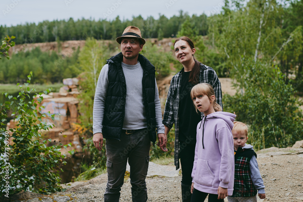 Happy family on a walk in the forest picking berries and herbs, traveling along paths and stones mom dad and children Happy family on a walk in the forest picking berries and herbs, traveling along paths and stones mom dad and children