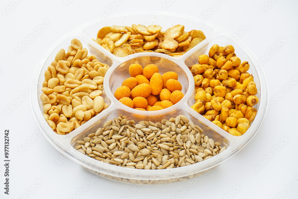 Salt food snacks collection assorted of nuts, seeds and corn on the plate isolated on white background. Salt food snacks collection assorted of nuts, seeds and corn on the plate isolated on white background.
