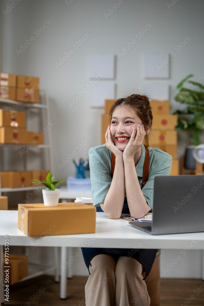 A woman is sitting at a desk with a laptop and a potted plant A woman is sitting at a desk with a laptop and a potted plant