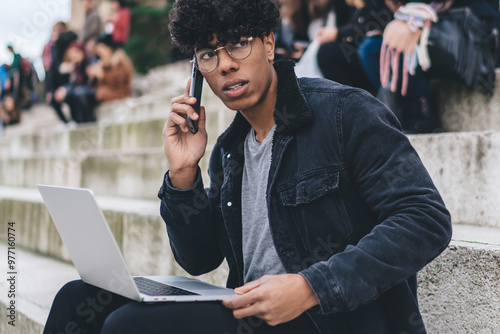 Canvas Print Contemplative man in trendy apparel received international cell call during dist