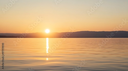 A soft, glowing sunset over a lake with a clear sky for text