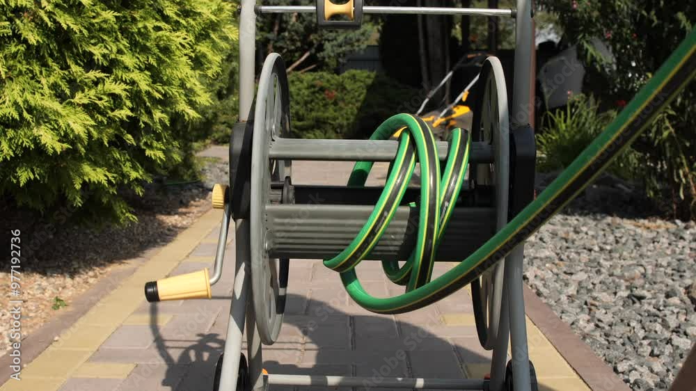 close-up Garden hose reel slowly rotating showing winding mechanism close-up Garden hose reel slowly rotating showing winding mechanism