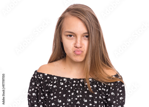 Canvas Print Teen girl in a black floral top making a pouting face, isolated on white
