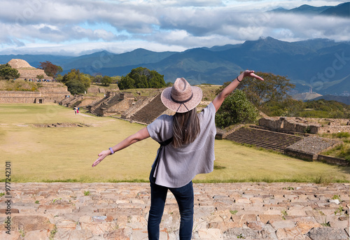 A female tourist wearing a beige straw hat on the steps of the Mayan pyramid in Monte Alban, Mexico photo