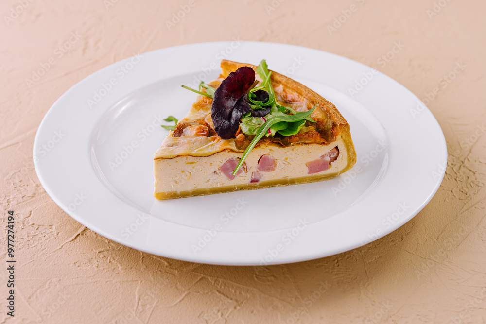 Slice of quiche lorraine resting on a white plate Slice of quiche lorraine resting on a white plate