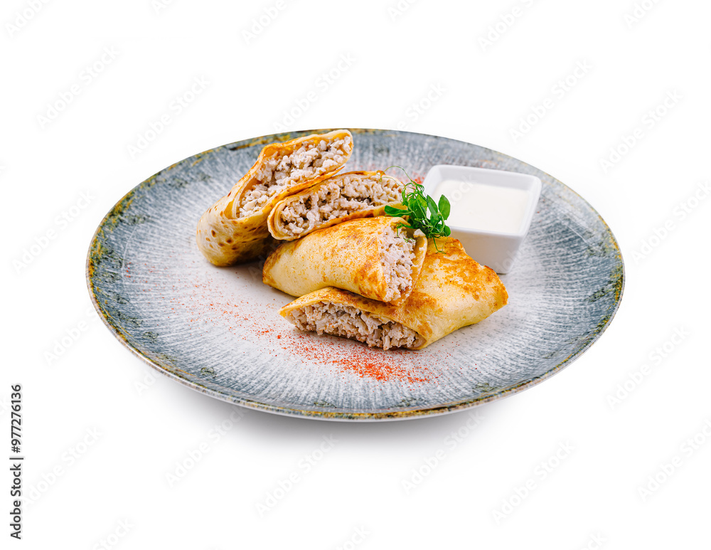 Pancakes with meat filling lying on gray plate with sour cream Pancakes with meat filling lying on gray plate with sour cream