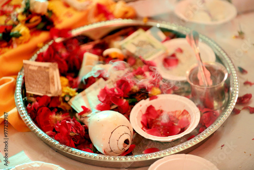 Indian pooja thali is a decorated plate used for rituals, containing a diya, incense sticks, kumkum, haldi, rice, flowers. It is essential for offering prayers to deities during religious ceremony. photo