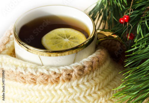 Tea with lemon. Beautiful mug with gold edging on the background of the New Year tree. photo