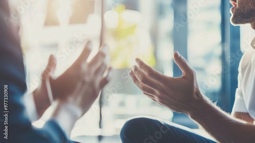 Close-up of two business people having a discussion  with their hands and gestures in conversation at a meeting room with a blurred background office interior. This business concept suggests the idea 