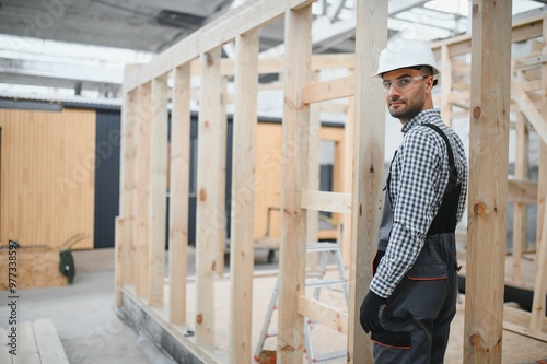 Process of construction new and modern modular house. Worker man in special protective uniform wear working on building development industry of energy efficient property