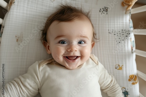 A wide-eyed baby smiling enthusiastically on a patterned blanket, surrounded by soft toys, symbolizing joy, innocence, and the playful spirit of childhood. photo