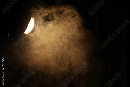 Professional spotlight and smoke in darkness. Space for text