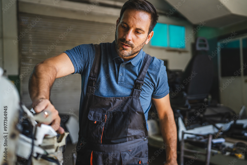 Focused car mechanic work in workshop wear blue polo shirt Focused car mechanic work in workshop wear blue polo shirt
