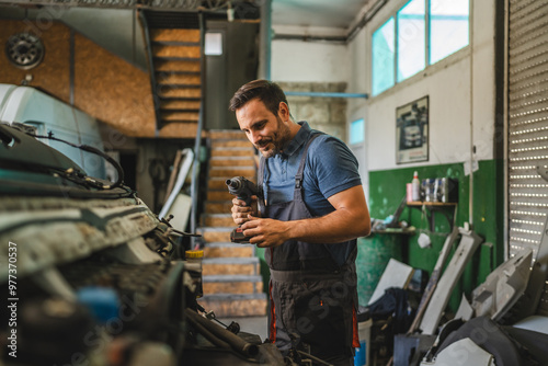 Car mechanic work on vehicle with drill tool in repair garage shop