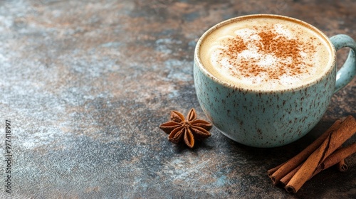 A cup of frothy cappuccino with cinnamon sticks, placed on a rustic surface, surrounded by space for text