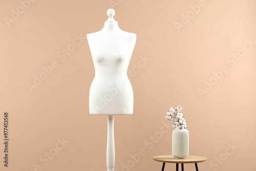 Mannequin and stylish vase on beige background