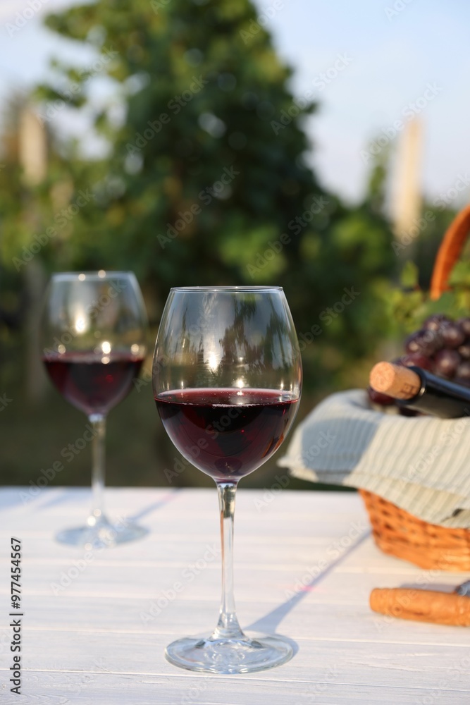 Tasty wine in glasses on white wooden table outdoors Tasty wine in glasses on white wooden table outdoors