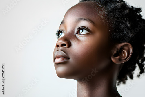 A close-up side view portrait of an African child girl with black skin against a white background,