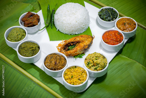 Traditional Bengali dishes such as bhorta, bhaji, fish curry, and vegetable curry are served in white ceramic pots and with Banana leaves.
