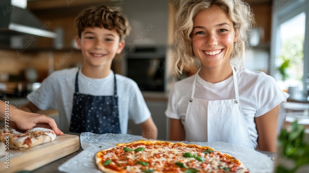 A delighted mother and her son in aprons are making a homemade pizza in their cozy kitchen, showcasing their bond and the joy of cooking together. A delighted mother and her son in aprons are making a homemade pizza in their cozy kitchen, showcasing their bond and the joy of cooking together.