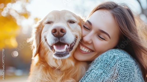 A woman smiles lovingly while embracing her dog in an outdoor setting, surrounded by golden-hued autumn leaves, capturing the essence of a cherished friendship. photo
