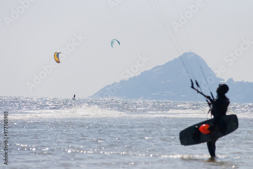 A breathtaking view of a kite surfer riding waves against a stunning coastal backdrop, showcasing adventure and freedom in nature.