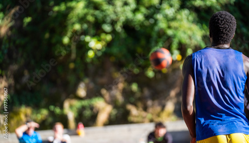 Street basketball player is playing basketball outdoors in the evening