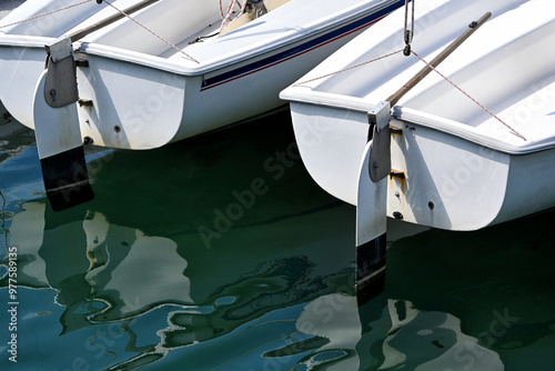 Φωτογραφία Closeup of two sailboats  with reflection in the calm harbor water
