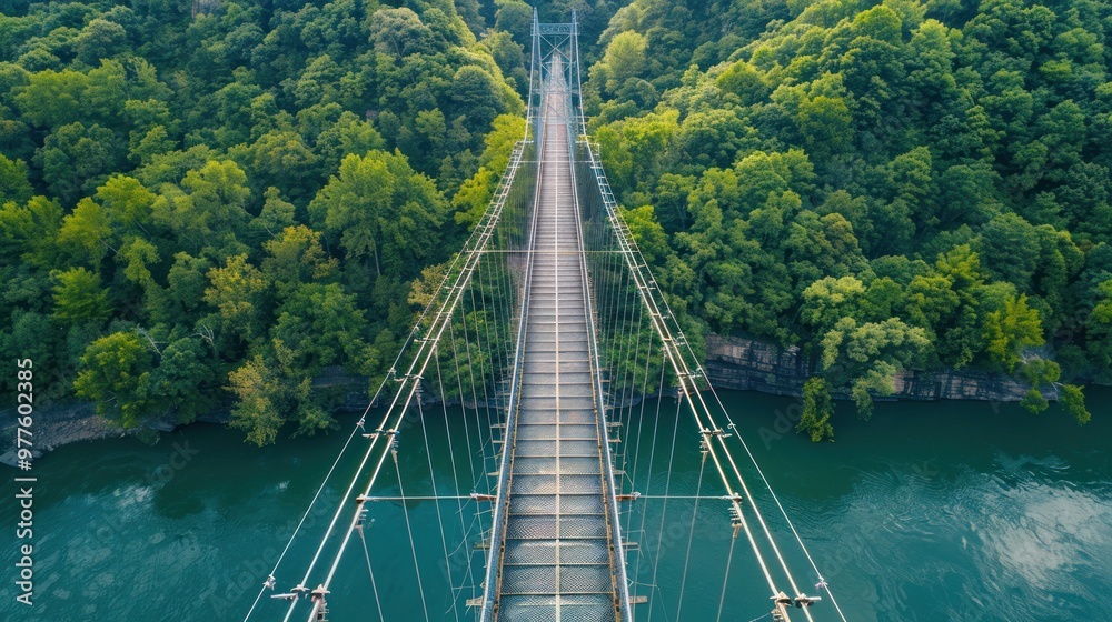 Obraz premium Suspension Bridge Over River in Lush Forest