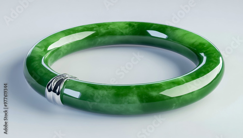 A shiny green jade bracelet with a silver clasp, studio shot on a white background.