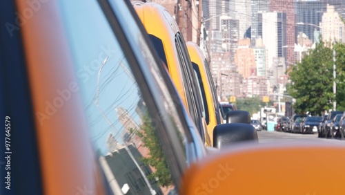 New York City. Row of yellow Taxi cars on street, Queens. Many taxi cabs on avenue, Long Island, LIC. Medallion taxicab and Manhattan Midtown urban skyline cityscape. High-rise building architecture.
