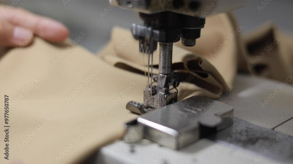 Sewing machines are working, producing clothes in a factory. Sewing machines are working, producing clothes in a factory.