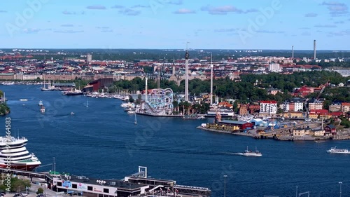 Boats navigate the bustling waterways near Grona Lund amusement park in Stockholm, Sweden. Vibrant scene showcases the lively atmosphere of Scandinavian city life photo