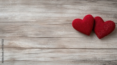 Two red hearts are placed on a wooden surface. Concept of love and warmth, as the hearts are a symbol of affection and care. The wooden surface adds a natural and rustic touch to the scene