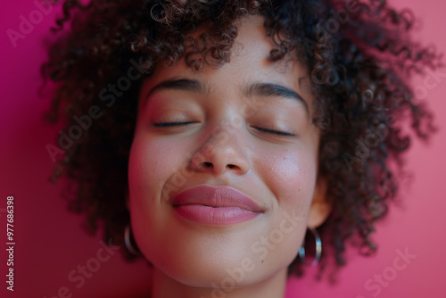 A woman with curly hair is smiling and looking at the camera