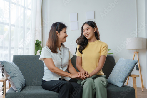 Quadro su tela Heartwarming moment between an asian mother and daughter as they hold hands and