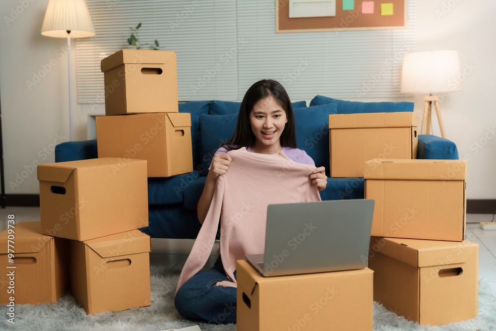 Confident asian entrepreneur presents her clothing line online through live streaming, exuding startup spirit and joy from home Confident asian entrepreneur presents her clothing line online through live streaming, exuding startup spirit and joy from home