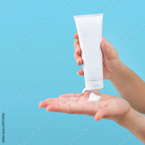 Hand pouring lotion or cream on hand, isolated background 